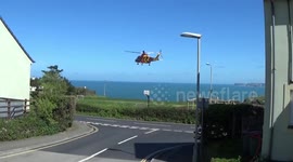 The Air Ambulance attempting a dangerous landing on the playing fields at Port isaac in cornwall then waiting for the ambulance,,1