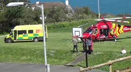 The Air Ambulance attempting a dangerous landing on the playing fields at Port isaac in cornwall then waiting for the ambulance, thank god its not windy