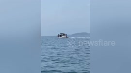 Locals transport tuk-tuk on motorboat in Cambodia