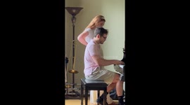 Dog attempts to steal the show from pianist.