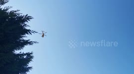Air Ambulance helicopter flies low over houses in Cleethorpes, UK as it lands in a nearby school field