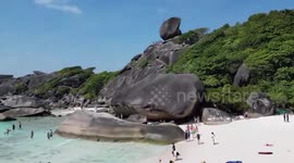 Rock shaped like boat sail precariously balancing on cliff attracts visitors in Thailand