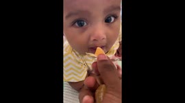 6 month old baby boy eating orange for the first time, watch his reactions