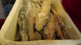 Palestinian sell salted fish to be sold in a market ahead of the Eid al-Fitr holiday, in Gaza city