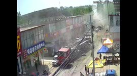 Pedestrians flee as two semi-trailer trucks collide in eastern China