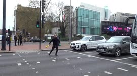 Young man is juggling clubs in the middle of West Cromwell Road in London