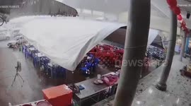 Strong wind blows tent roof from funeral marquee during storm in Thailand