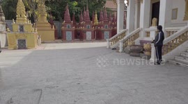 Locals play street game sliding wood at bundle of notes in Cambodia