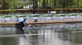Disabled athlete Stuart Bloor struggles in the rain as he goes through Canary wharf at the London Marathon