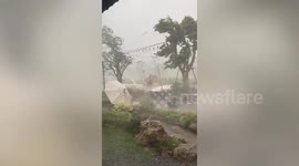 Cafe battered by wind and rain as heat wave brings storms in Thailand
