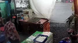 Waitress battles to secure cafe as tropical storm hits Thailand
