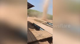 Dust devil sweeps through car park in rural Thailand