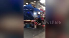 Terrified vendors hold onto tents as freak storm blow stalls away in Thailand