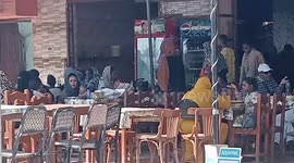 Sudanese get off buses and rest at café near Qustul, Egypt, on border with Sudan