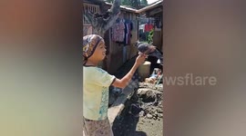 Mute little boy plays with friend pigeon outside his home