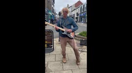 Local Busker Glen Lawrence on his electric guitar in Aberystwyth, West Wales, UK