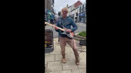 Support local buskers! Glen Lawrence busker in Aberystwyth, West Wales on Great Darkgate Street, UK.