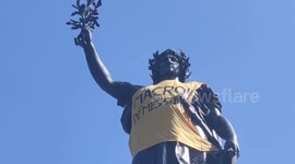 Marianne statue wrapped with 'Macron resign' banner after May Day protests across France