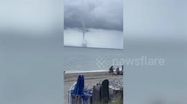 Gigantic waterspout forms beside local thunderstorm off the coast of Florida