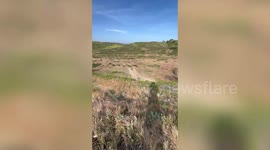 Dirt bike rider crashes onto grass while jumping uphill in California