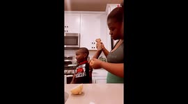 Kid cannot stop laughing as mother helps him apply a deodorant