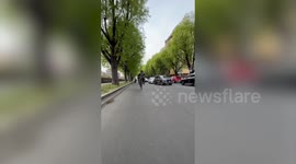 Biker performs impressive wheelie stunt while swerving along busy road in Italy