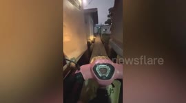 Motorcycle drivers skillfully navigates narrow alleyways to reach home