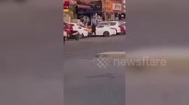 Policeman distracts rifle-wielding gunman so his colleagues can arrest him on busy street in Iraq