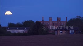 Full Flower Moon seen rising above Gatehouse in Kent, UK