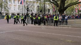 A person who is camping overnight in St Jane's Park walks around carrying his tent