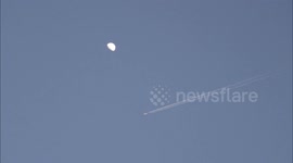 A Plane Flies Under The Moon in Yichang, China