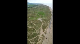 Drone portrait view of Talacre beach in wales with the lighthouse and dunes