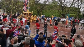 A fan's eye view of Charles riding in his golden carriage along the Mall