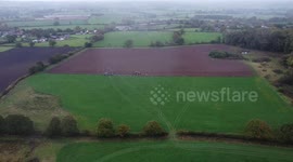 Fields getting ploughed by tractors and birds looking for worms drone shot