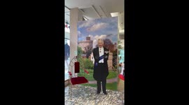 Cardboard cut out of King Charles III with chair next to him to pose in. Located at Daniel Department store in Windsor.