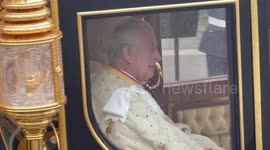 Closeup shot of Charles and Camilla arriving at Westminster Abbey in golden carriage