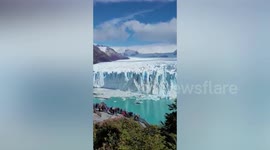 Chunks of ice breaks off glacier and crashes down on frozen lake