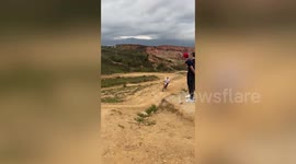Dirt biker falls off motorcycle while drifting across sandy terrain in Colombia