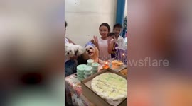 Cute pet dog smiles while kids sing happy birthday to her