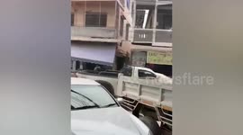 Orange pet cat hitches ride on roof of moving car in Myanmar