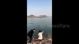 Chinese girl's attempt at skipping stones goes wrong, injures father