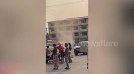 Dust devil tornado whips through car park on hot day in Thailand