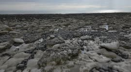 Drone 4k footage over rocks and shoreline to the sea at low altitude