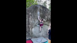 Woman Bouldering in Fontainebleau in France and celebrating after a hard climb is completed