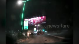 Billboard collapses onto road during storm in Cambodia