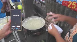 Talented street food vendor rapidly flicks rice balls into pot like machine gun to keep up with orders