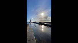 Cautious Walker Soaked by Sudden Wave