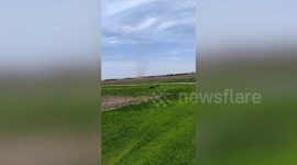 Frantic local spots dust devil tornado rotating in fields in Illinois (contains strong language)