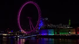 Rainbow of lights across the River Thames with London Eye, County Hall and Westminster Bridge glowing at night