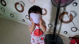 Funny baby girl playing mum's bra pad